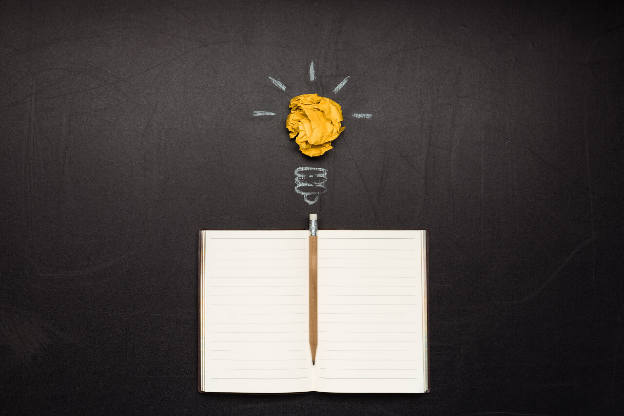 灯泡符号和空白笔记本铅笔思维思考