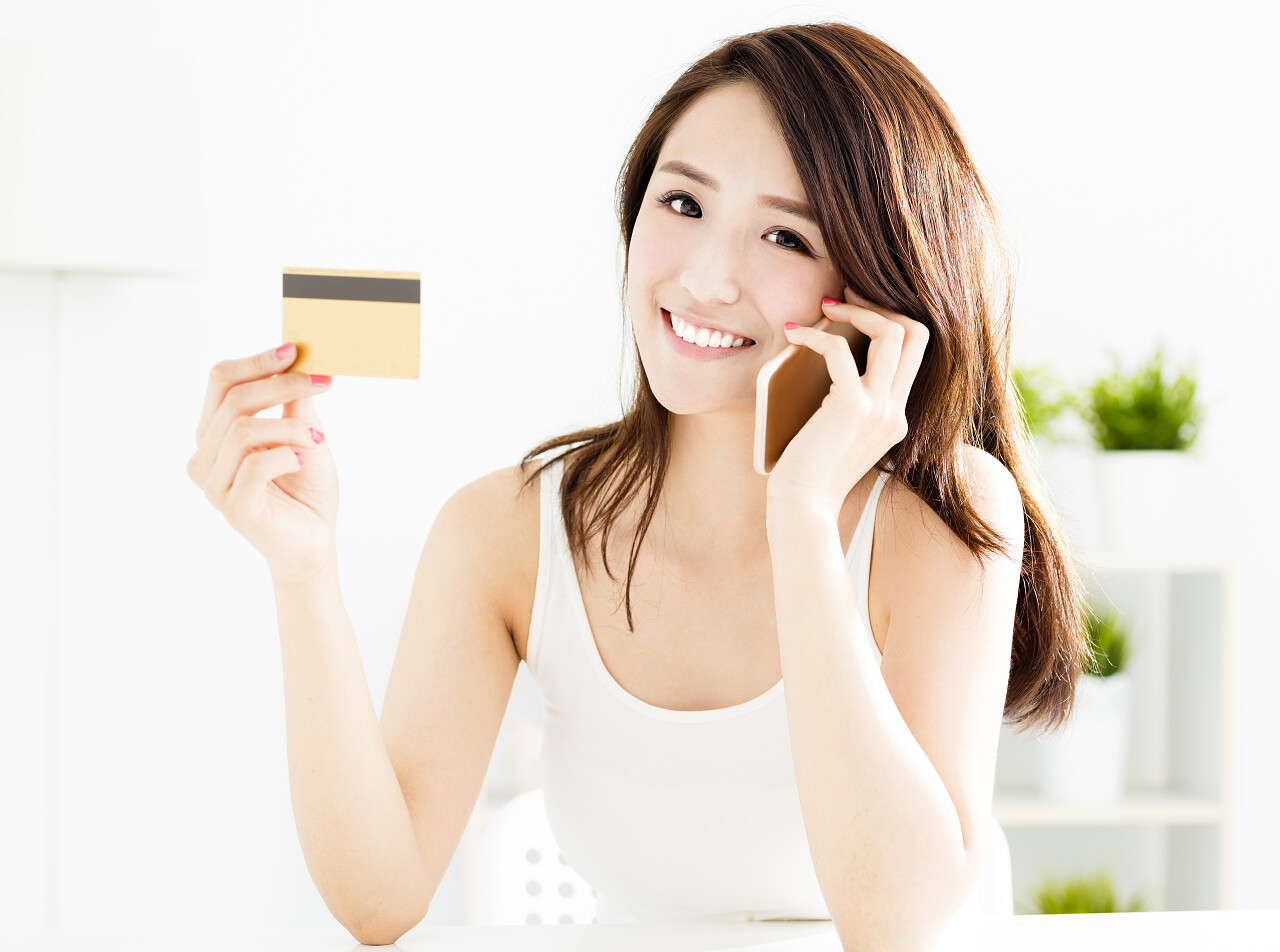 女人使用信用卡与智能手机