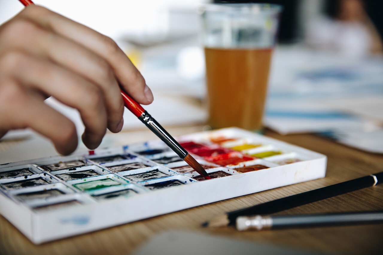 拿着画笔绘图用水彩颜料画