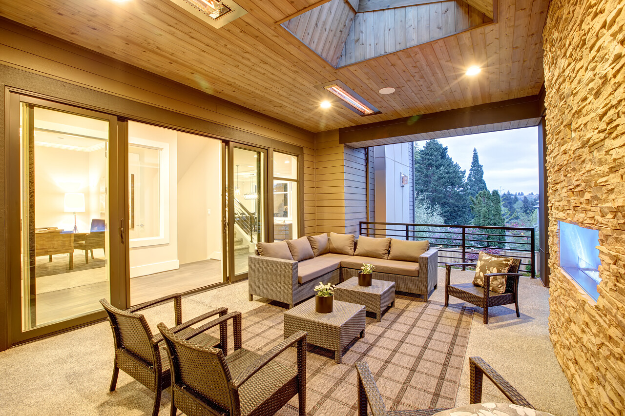 梦幻般的户外天井与石壁炉天花板与天光藤条扶手椅沙发