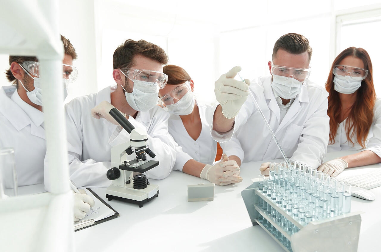 年轻的医生正在与试管和显微镜实验室