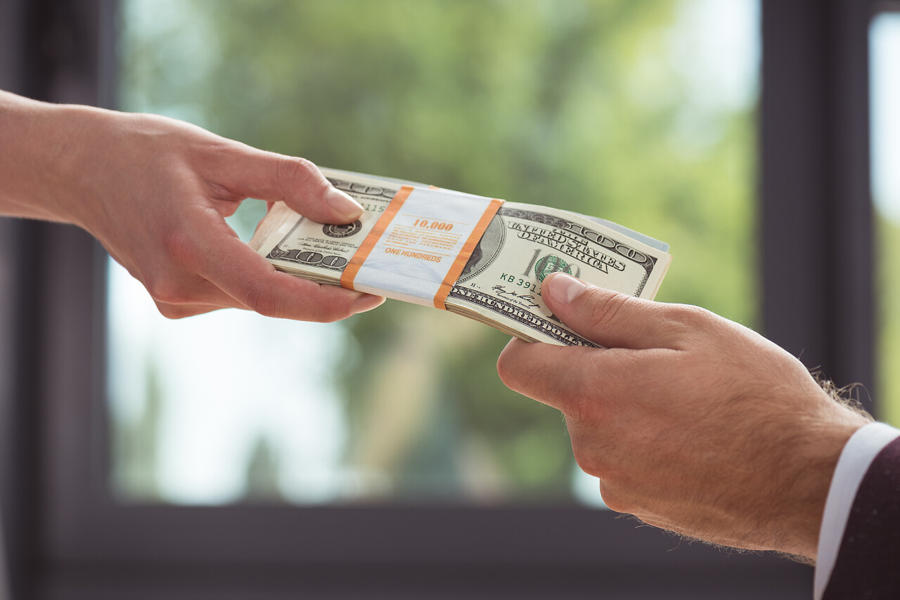 剪裁的商人持有美元钞票工资概念视图