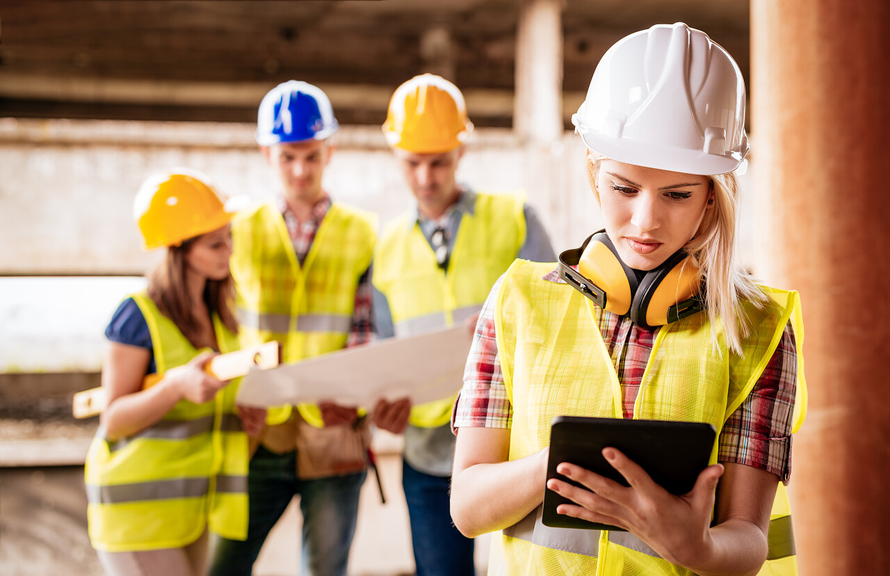 带头盔和黄色夹克的妇女建筑师