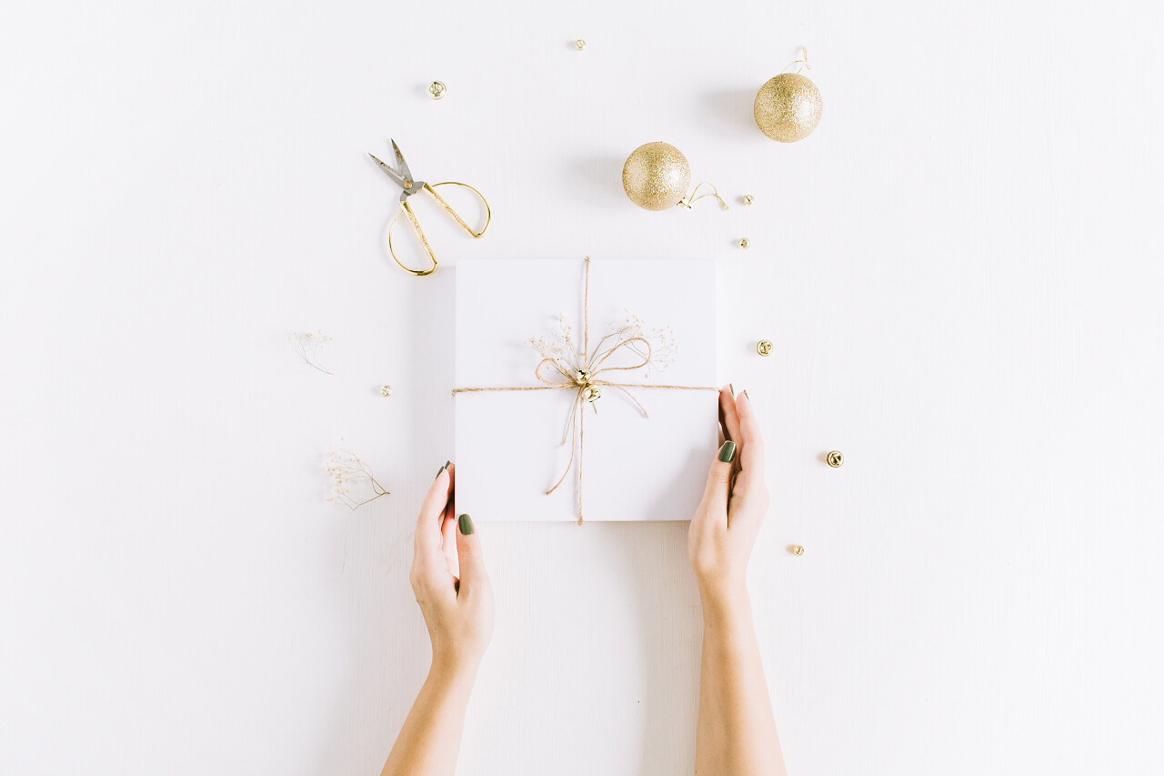 手持白色礼品盒的女性手