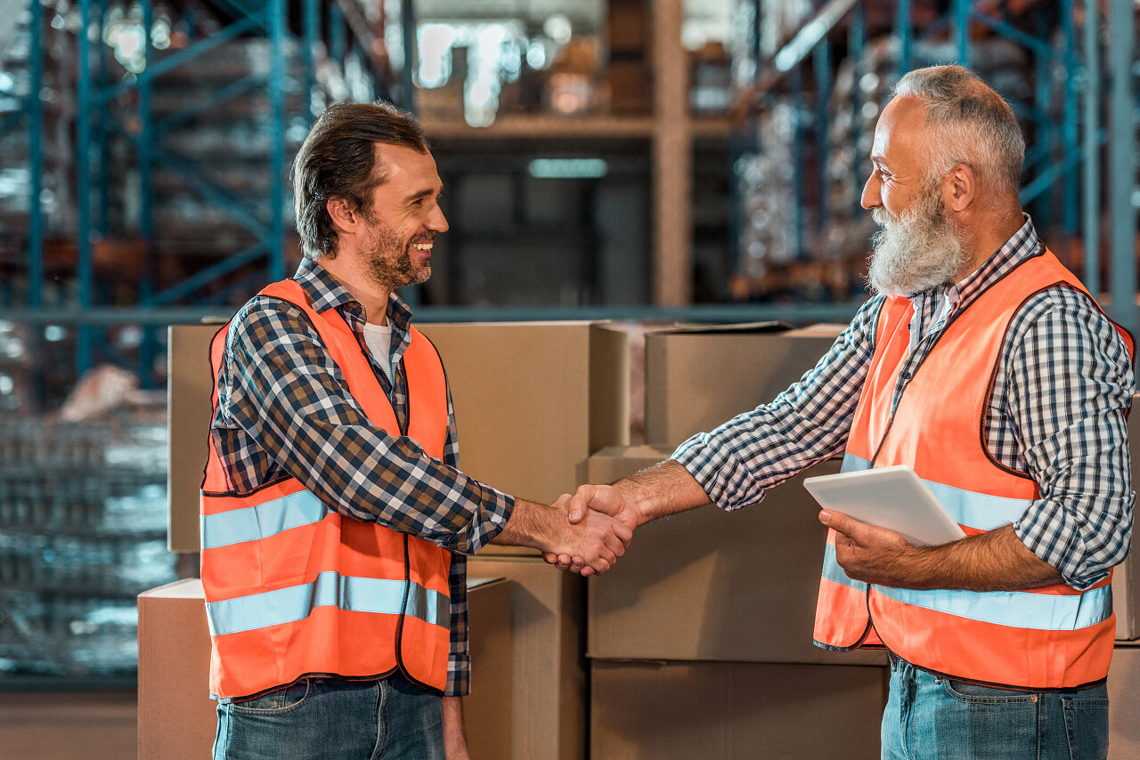 微笑仓库工人握手团结握手货物物流人员物流仓库物流园区