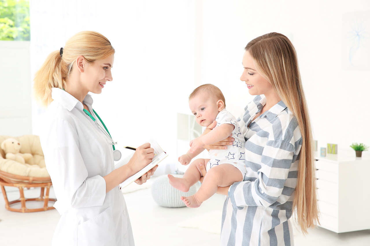 医生写的东西在笔记本和母亲与婴儿在家医生看诊病人儿科医生