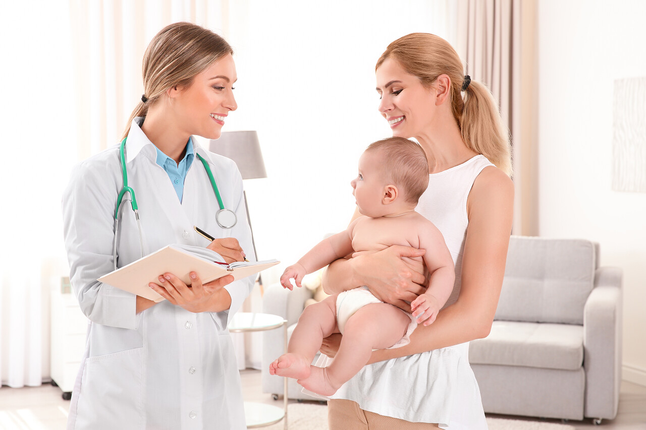 医生写的东西在笔记本和母亲与婴儿在家医生看诊病人儿科医生