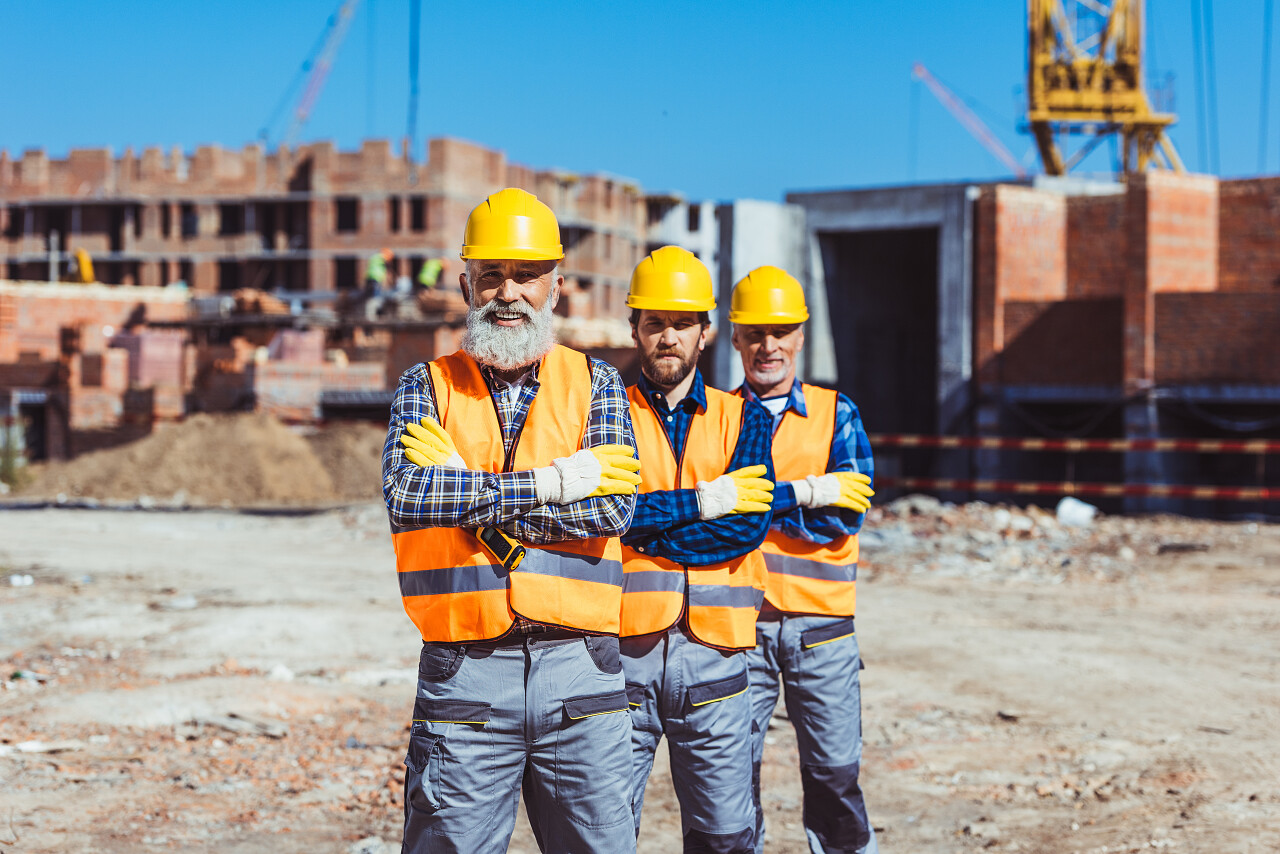 三个工人与武器合影交叉在施工现场