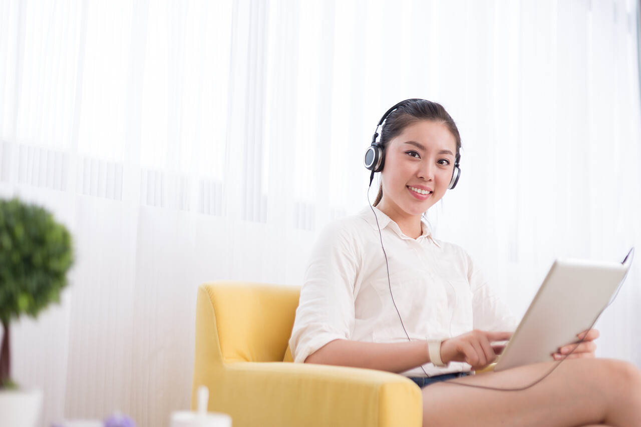 年轻漂亮的中国女人在房间里听音乐