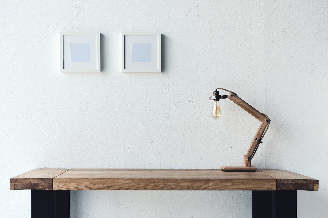 空白照片相框挂在墙上的工作场所与台灯