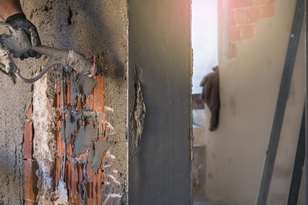 建筑工人在用抹灰机涂水泥