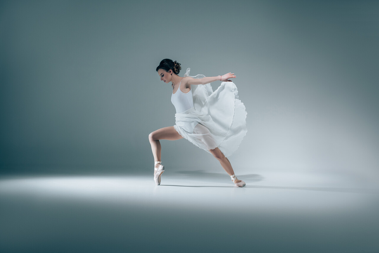 优雅的芭蕾舞演员穿着白色礼服跳舞