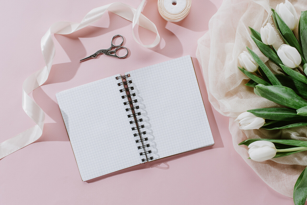 桌子上的日记本和鲜花日记情人节三八妇女节38妇女节