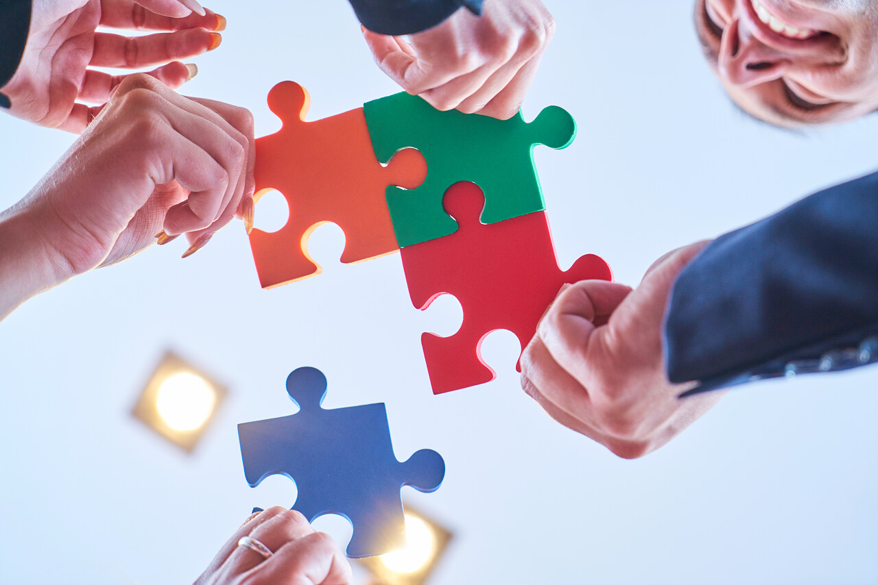 集团的业务人员组装拼图和代表团队支持和帮助概念在现代办公室团队协作团队合作团队拼图