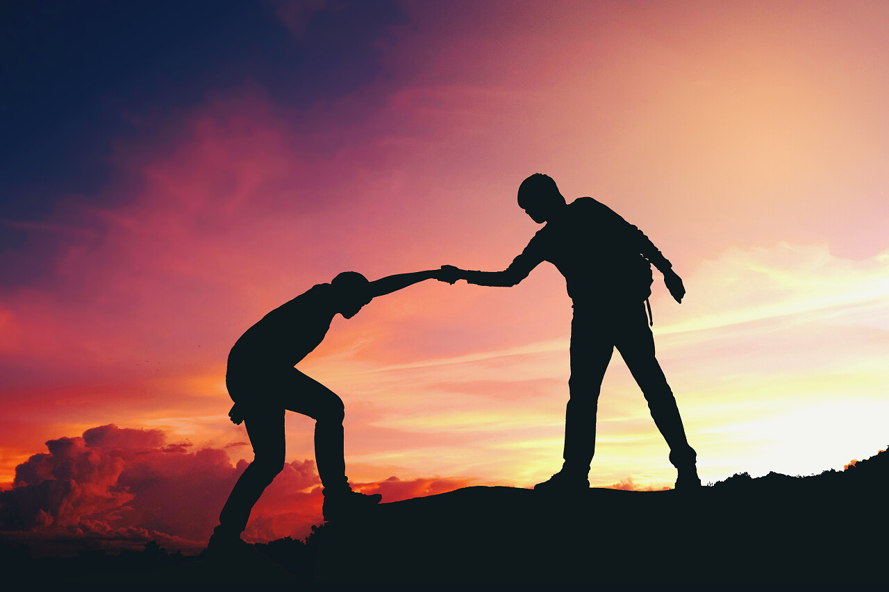 团队合作夫妇帮助徒步登山的剪影在山上励志努力坚持不懈克服困难救命