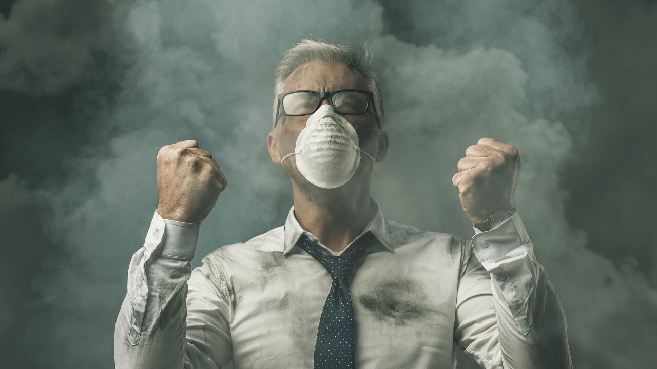 愤怒的商人举起拳头和污染的空气奋斗拳头