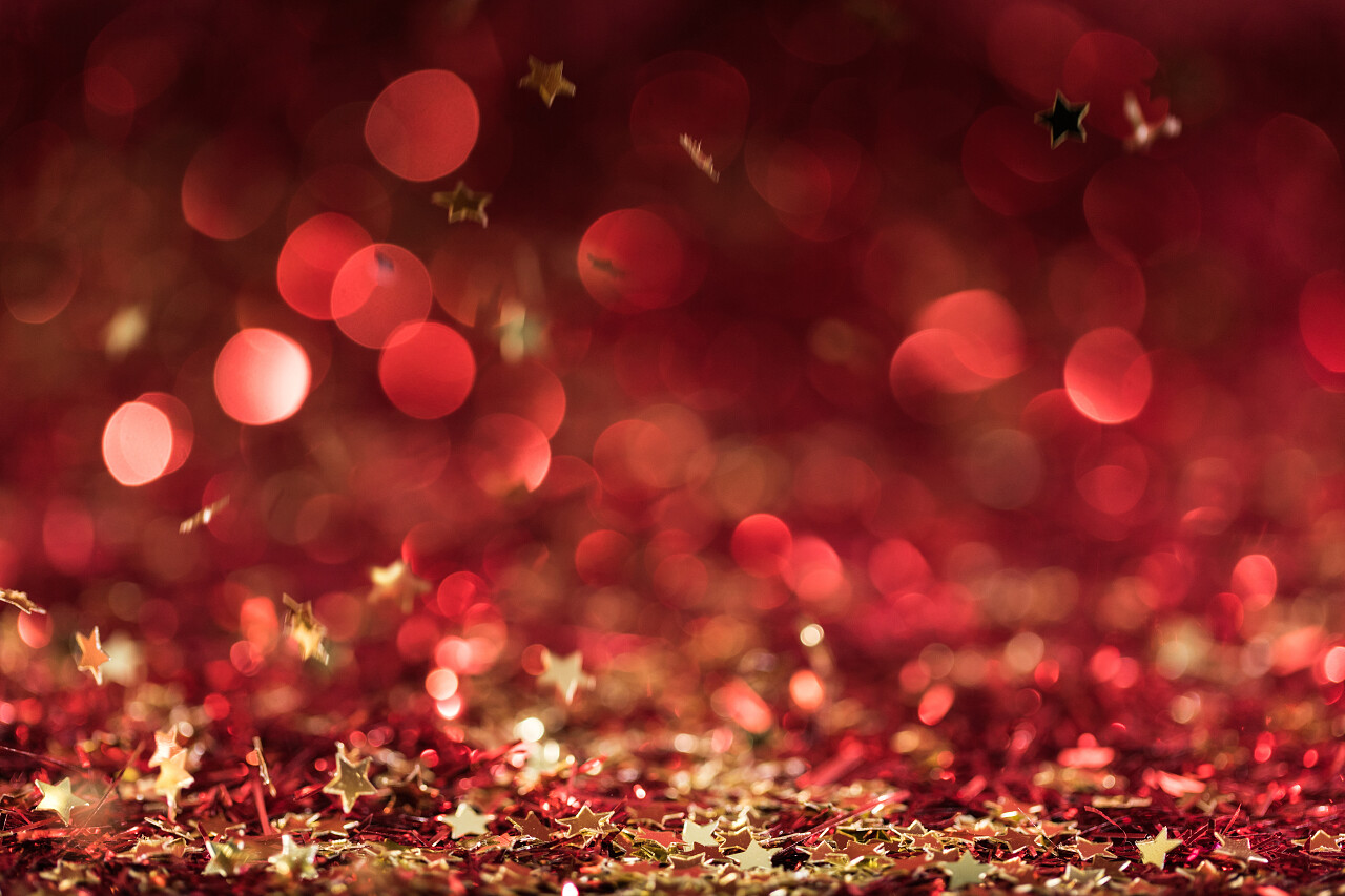 圣诞纹理与下降的红色闪亮的五彩纸屑明星