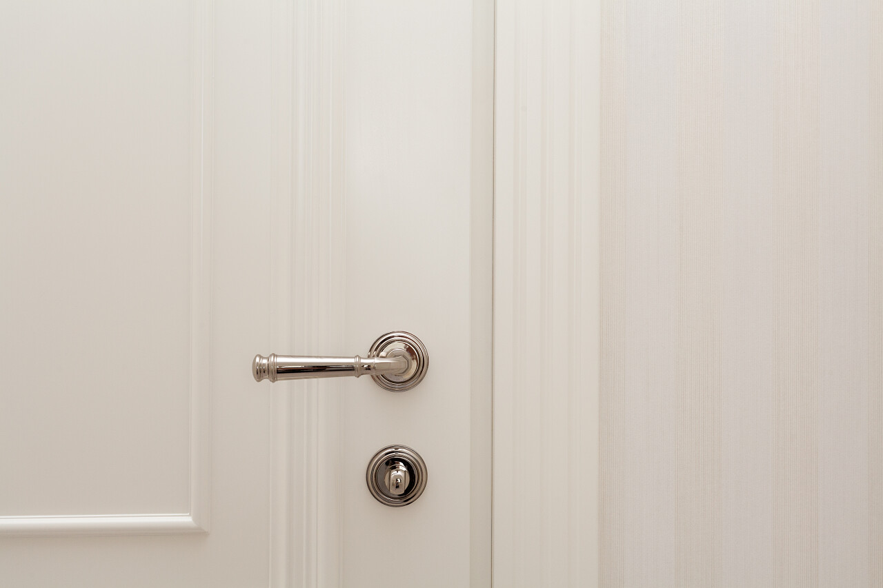 用金属手柄关闭白色门.