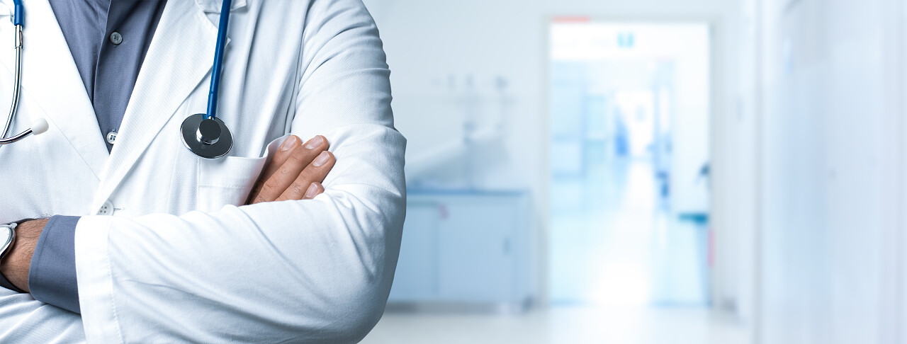 自信的医生摆着手臂交叉和听诊器