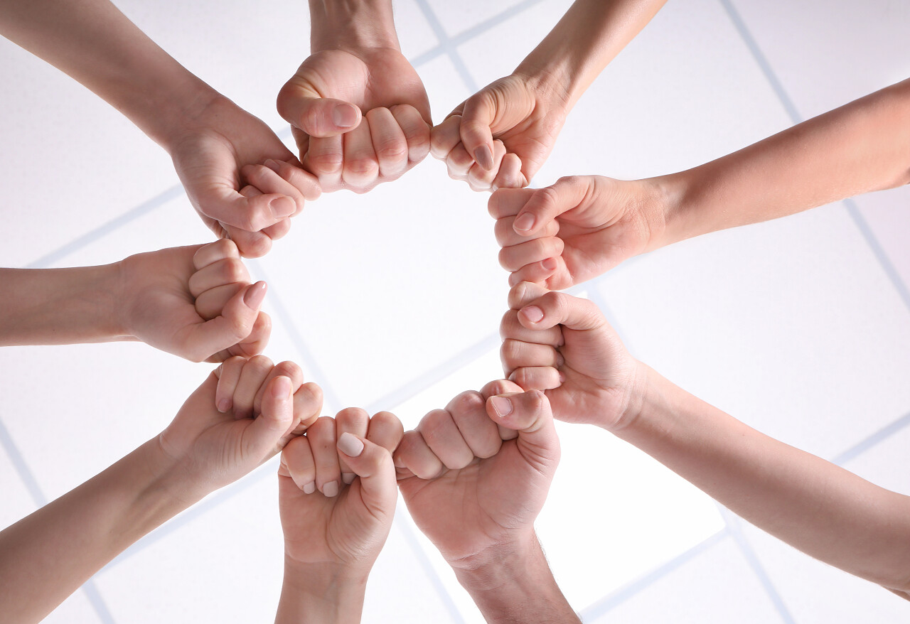 年轻人把他们的拳头在圈子作为团结的标志团队加油团结拳头团结手势激励