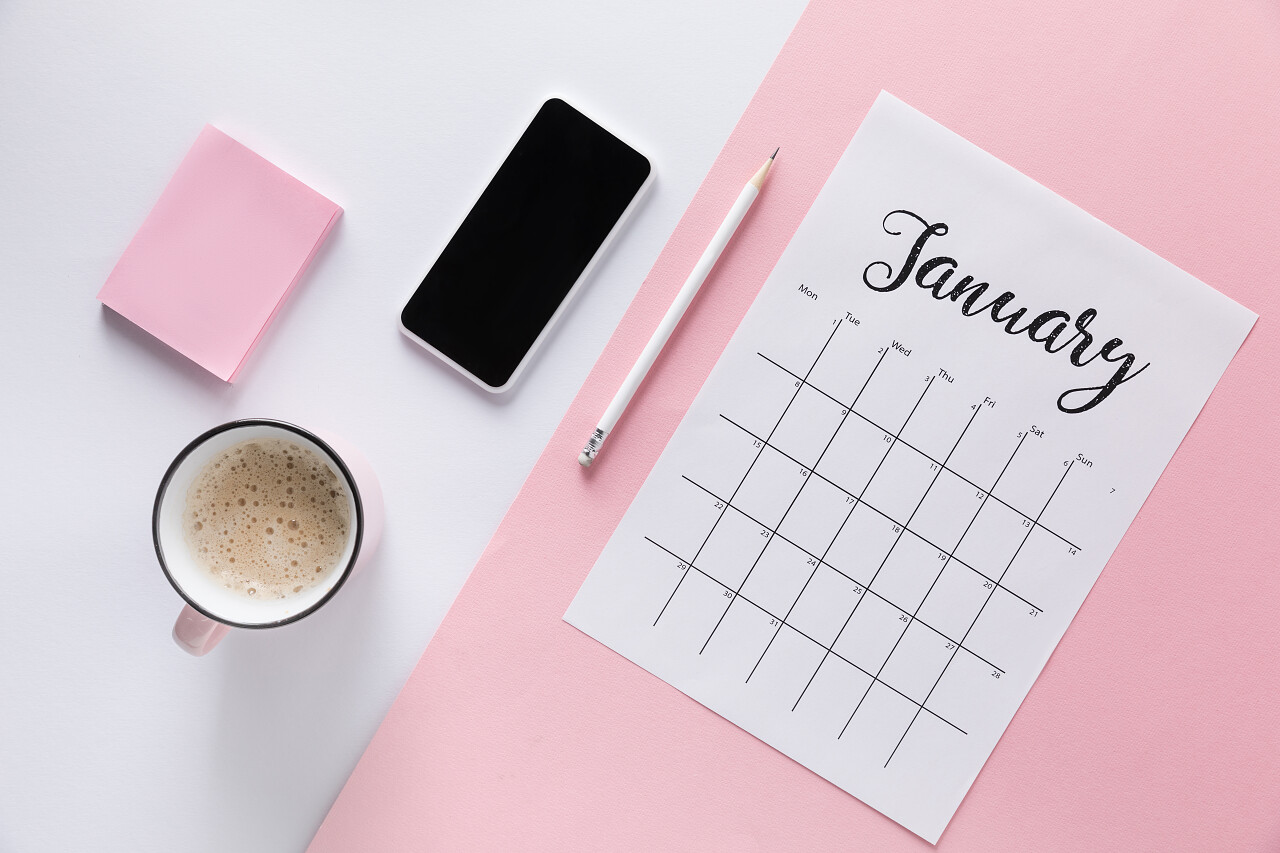 平躺与日历智能手机杯咖啡和空白的粘音符