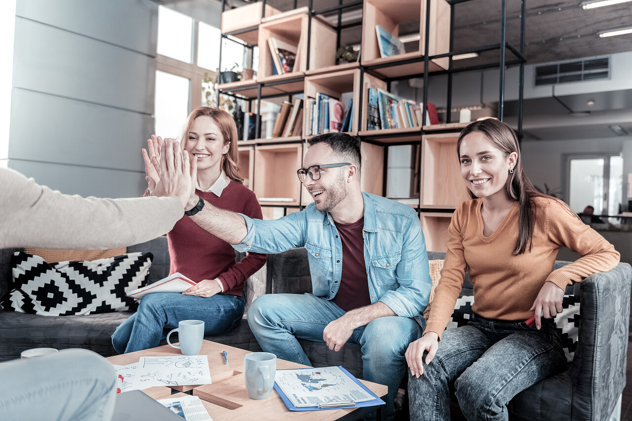 我的滑稽同事漂亮的快乐时髦的女人坐在她的朋友微笑
