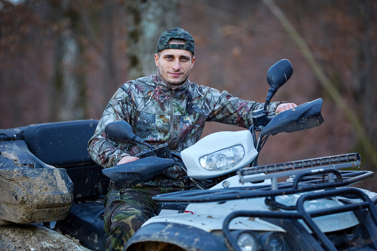 在森林里寻找游戏的年轻猎人在四自行车猎人