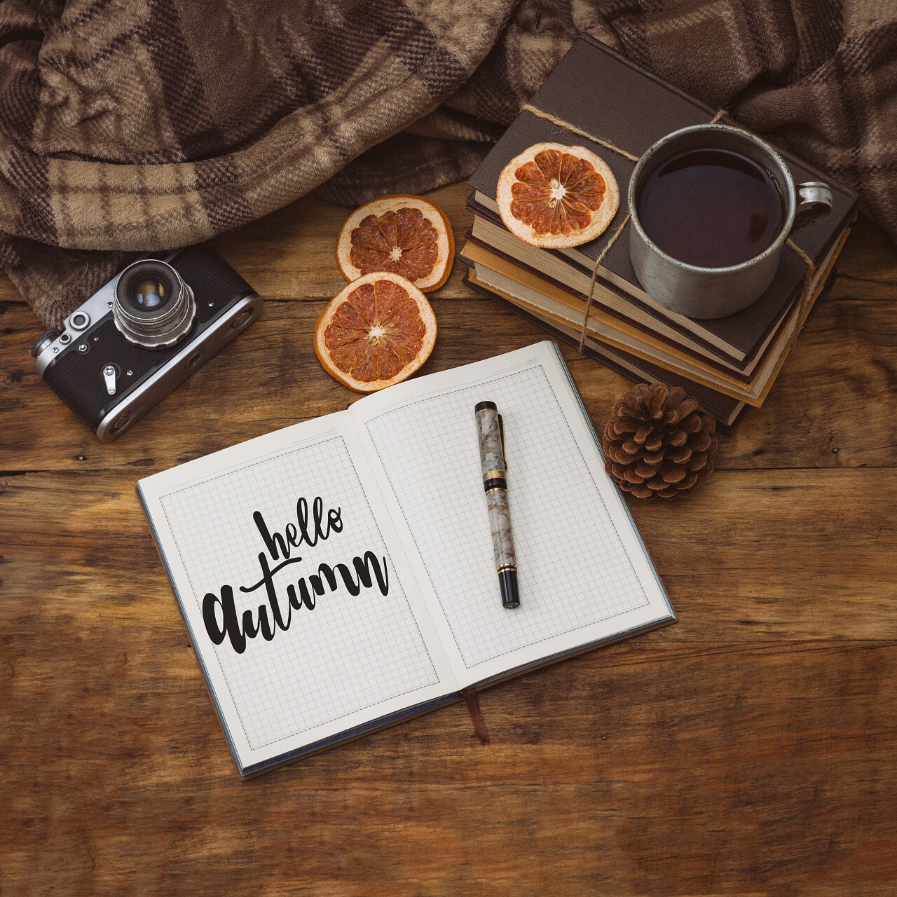 一个古董杯里面有热茶书毯子和木制背景的一张纸