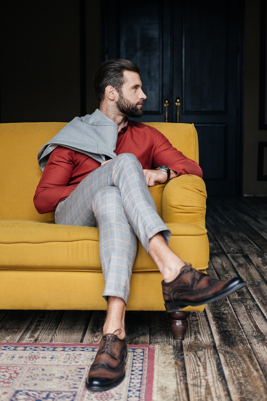 时尚男士坐在阁楼的黄色沙发上家居模特·