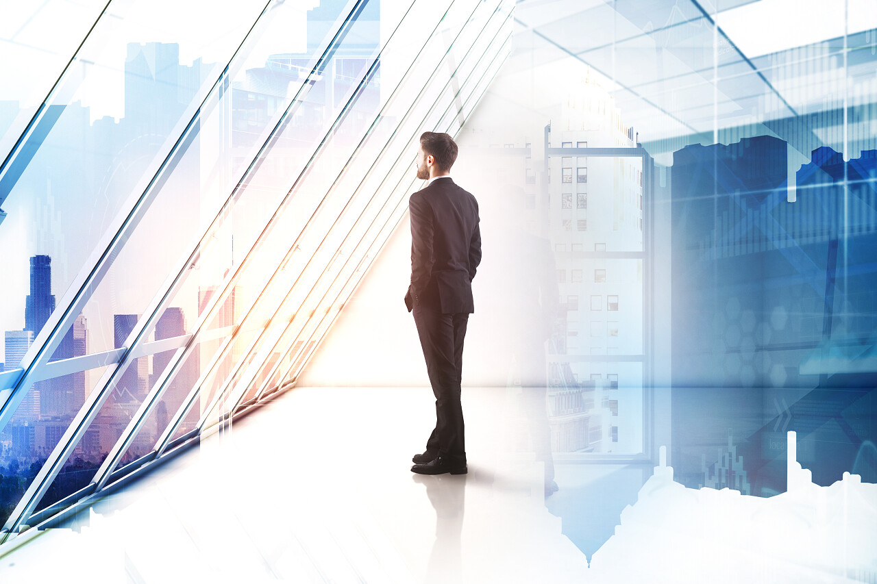 年轻商人的侧面看着窗外的现代内部