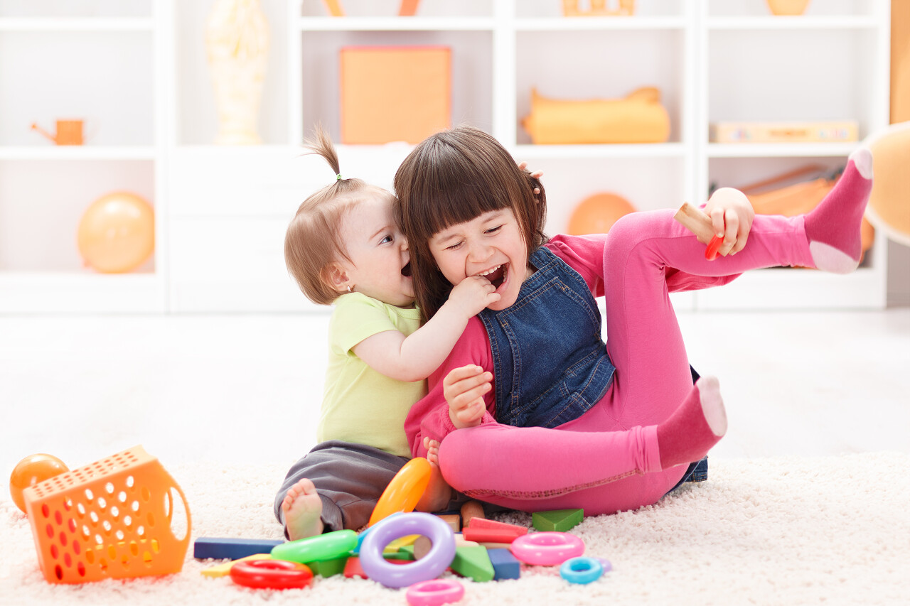 小女孩和她的妹妹玩玩具微笑的小女孩