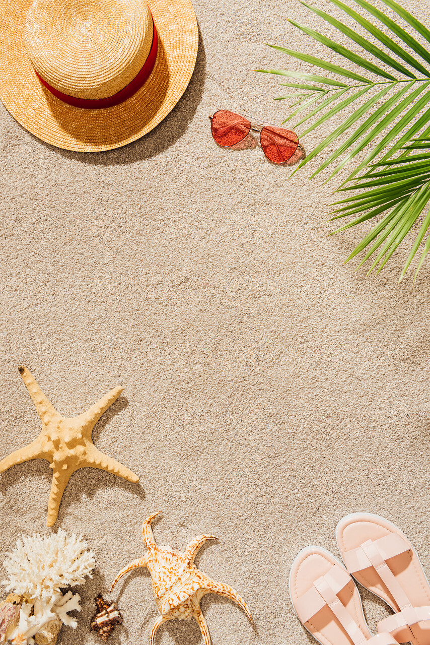 沙滩上的太阳镜和凉鞋的时尚帽子的顶级视图