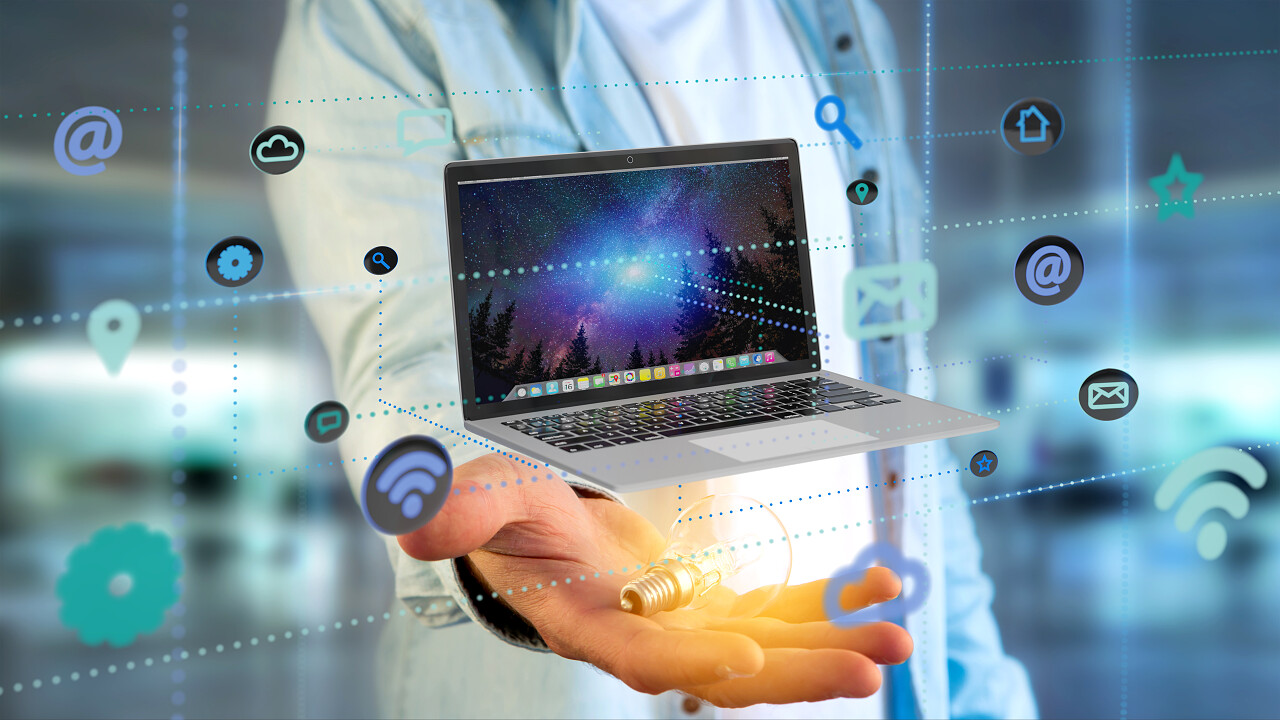 一个商人持有电脑的周围有着应用程序和社会图标