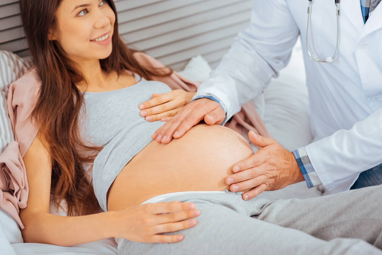 放大看一个医生抚摸着一个期待的母亲幸福的人