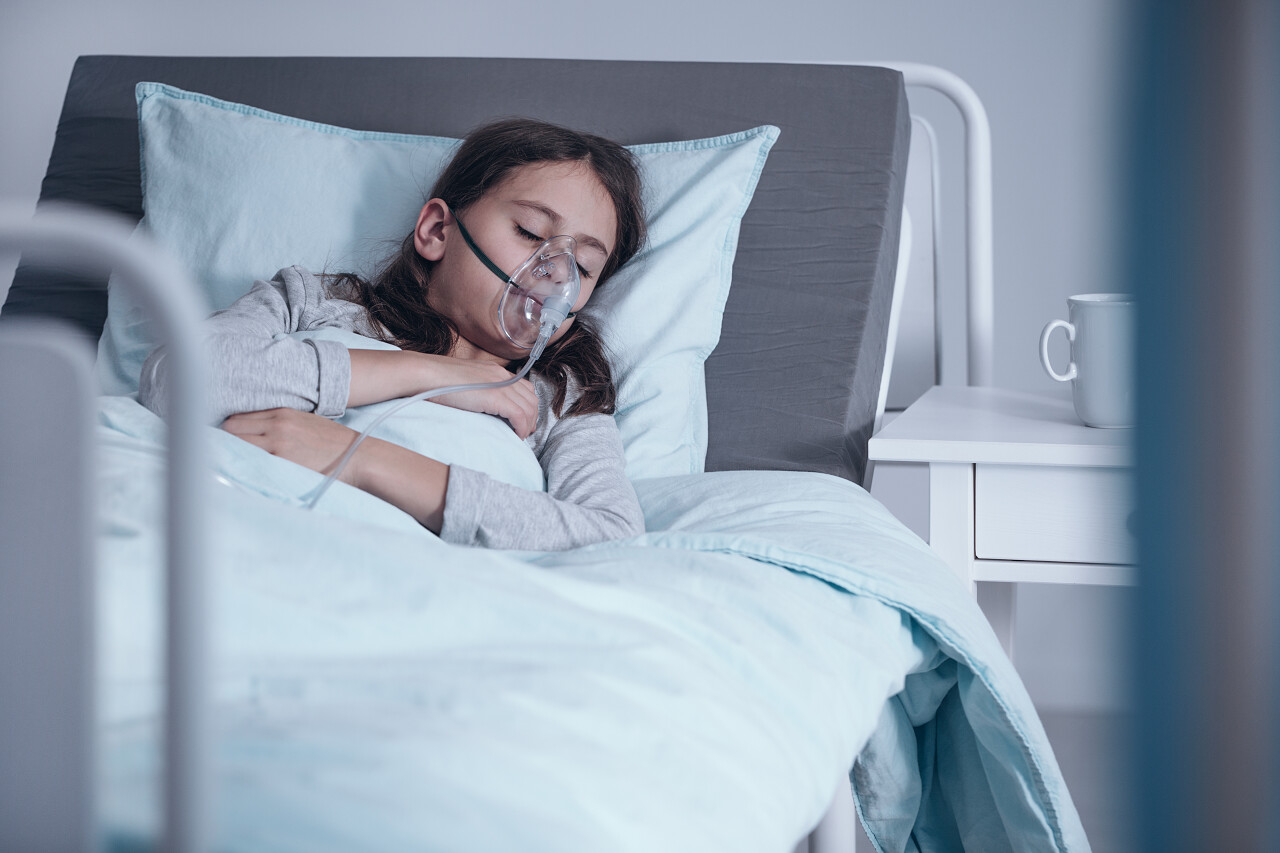 躺在病床上脸上戴着氧气面罩的年轻女孩