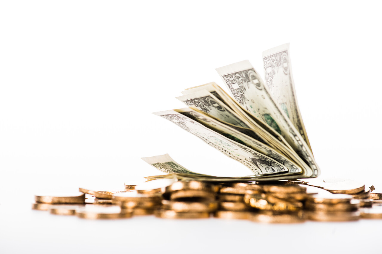 近距离查看美元钞票和闪亮的金色硬币孤立白色