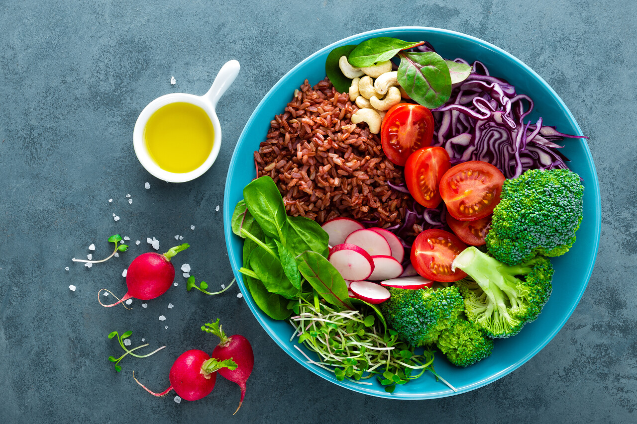 碗里有紫甘蓝和菠菜和甜菜叶还有糙米和西红柿