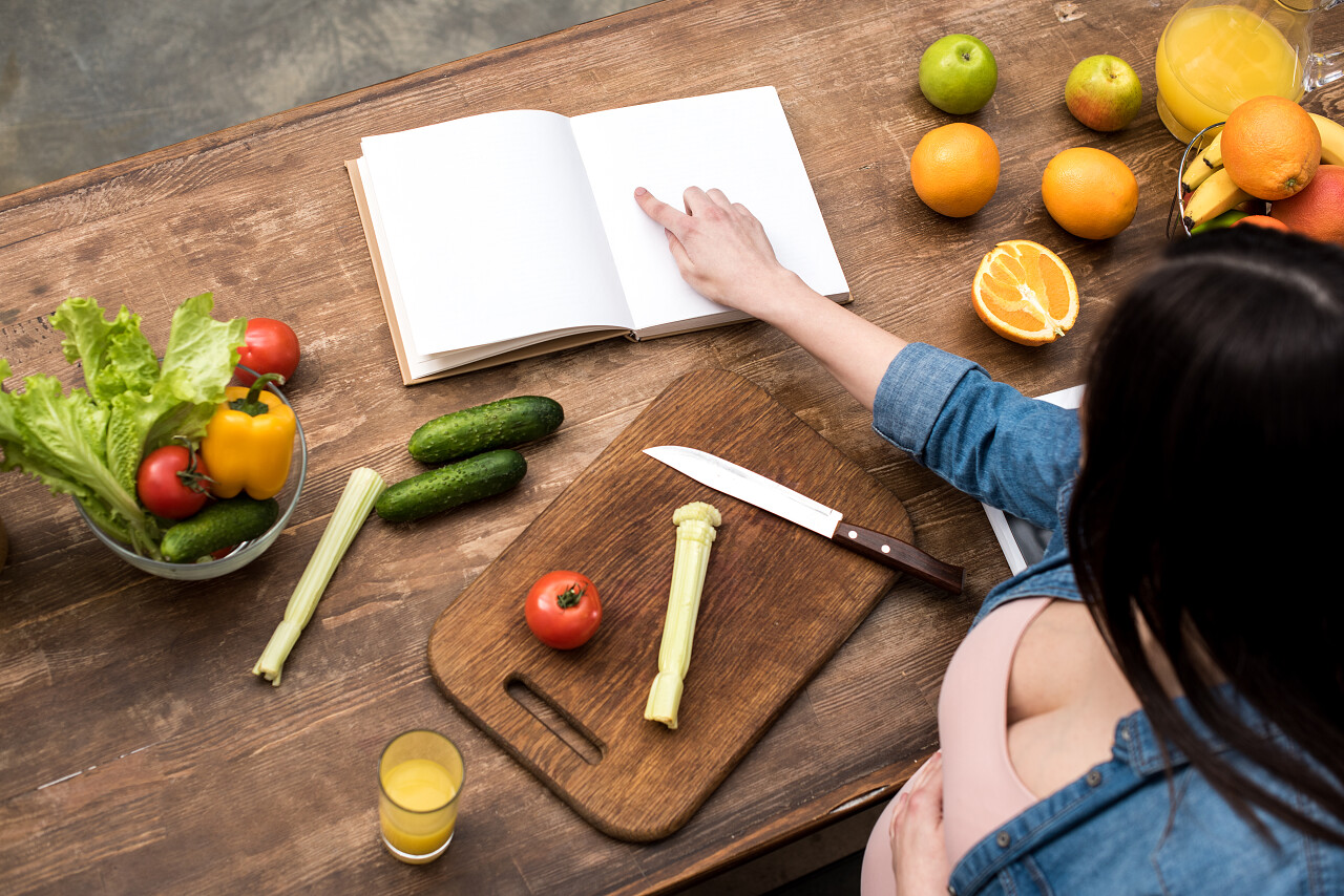 孕妇在厨房烹饪时阅读食谱的照片