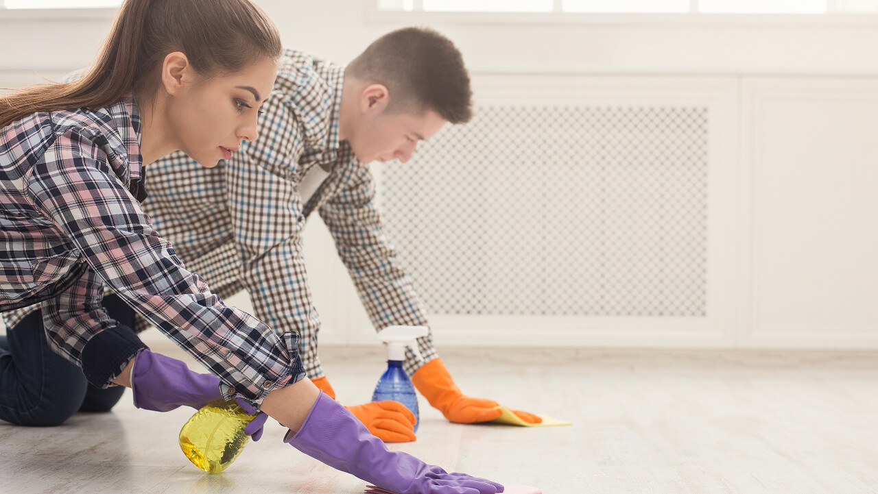 年轻夫妇用橡皮手套在家里打扫卫生用毛巾洗地板世界卫生日
