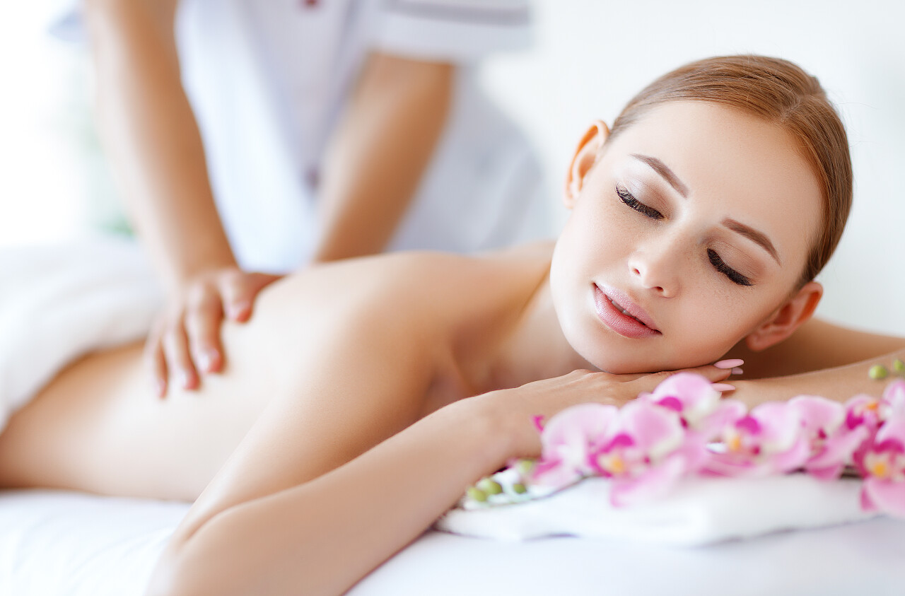 一个美丽的女孩享受按摩幸福的人背部背部按摩