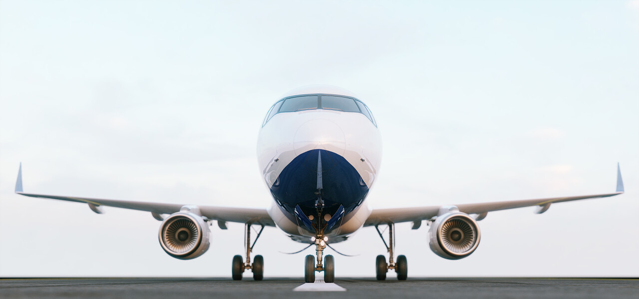 白色的商用飞机在日落时站在机场跑道上