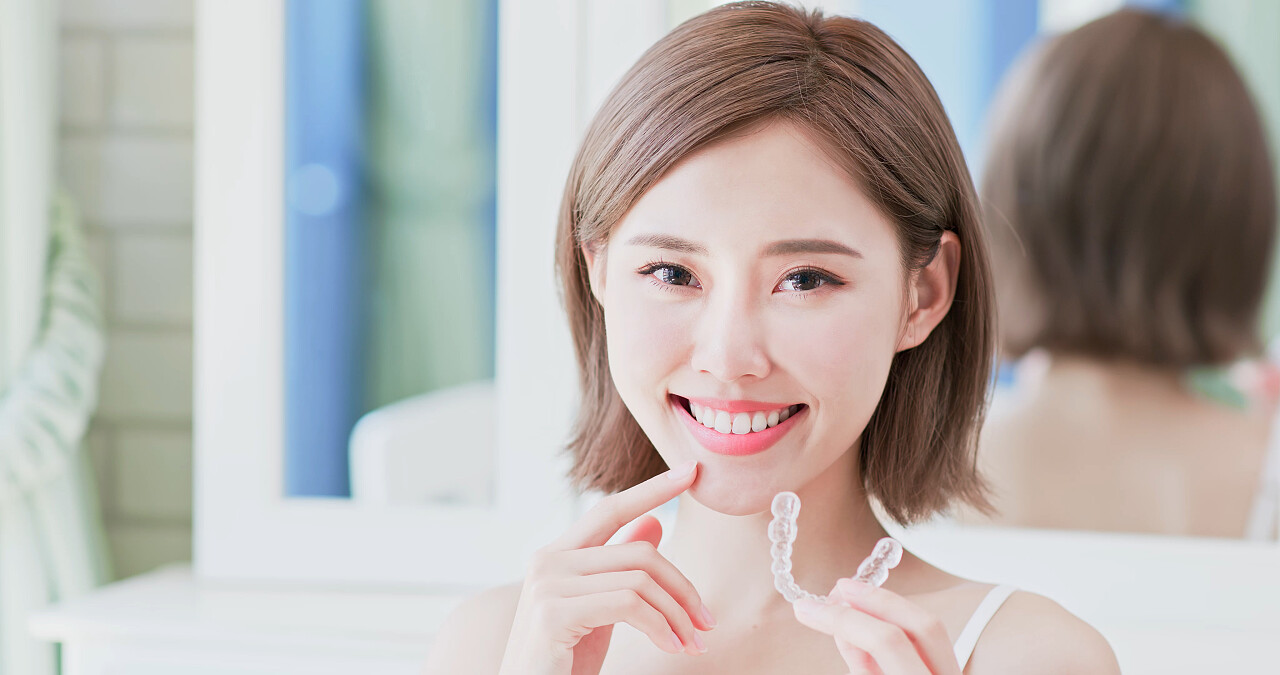 关闭的女人微笑着与无形的牙套幸福的人牙齿美白牙齿矫正修复口腔牙齿口腔牙齿