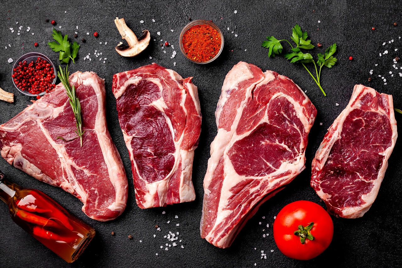 肉生牛排位于黑色的背景蔬菜