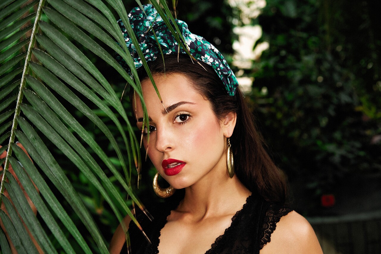 漂亮的年轻女子在优雅的头饰与各种手镯摆在户外