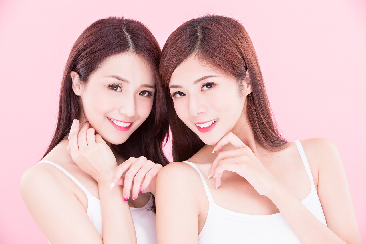 两个美容护肤的妇女与健康的牙齿在粉红色的背景牙齿美白口腔牙齿口腔牙齿笑脸笑容