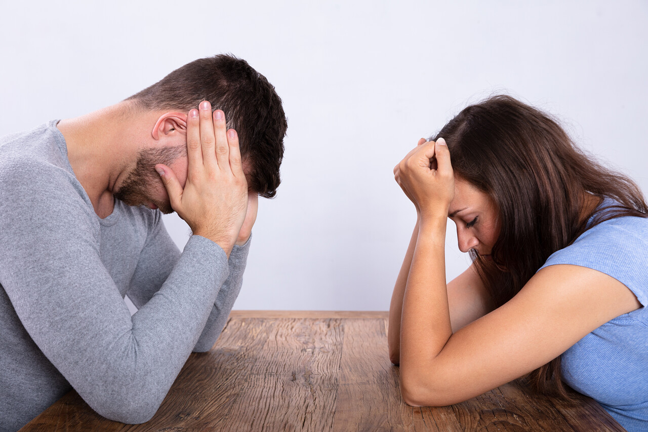 一对沮丧的年轻夫妇坐在对面的看法沮丧人物烦躁恼火烦躁