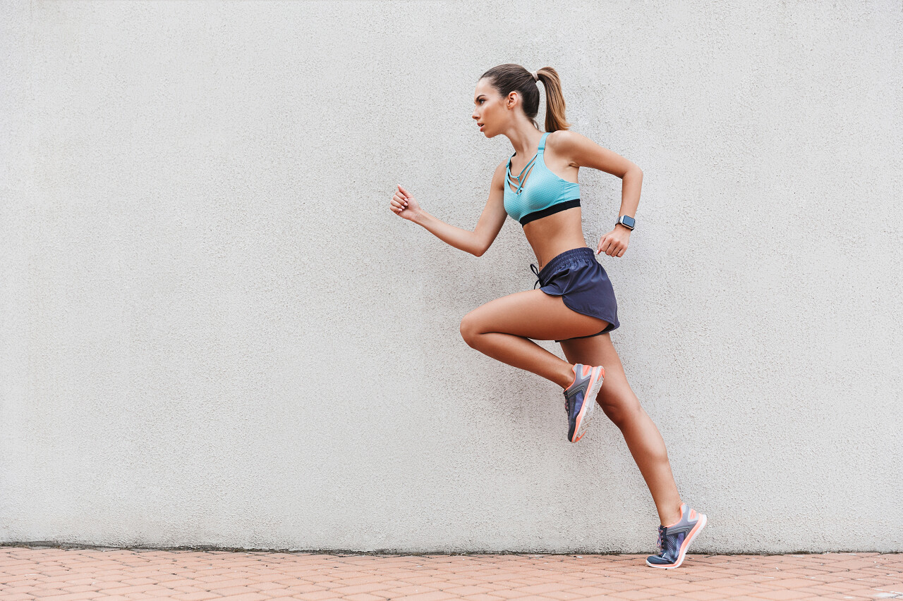 集中年轻的运动员穿着运动装在户外墙上热身