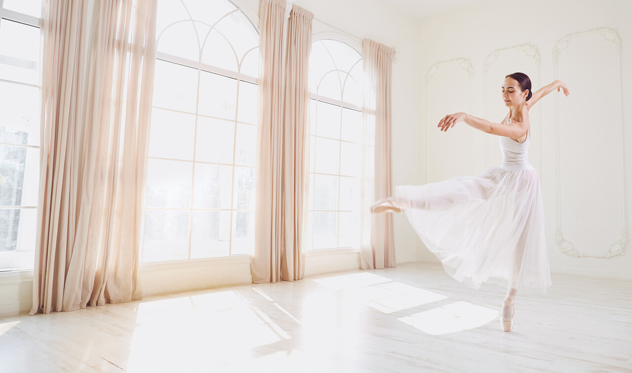 芭蕾舞演员在白色背景窗口的工作室跳舞.