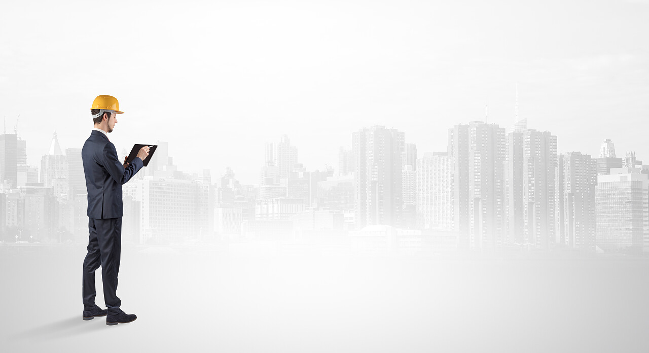 年轻的监督员建筑师站着看着大城市全景