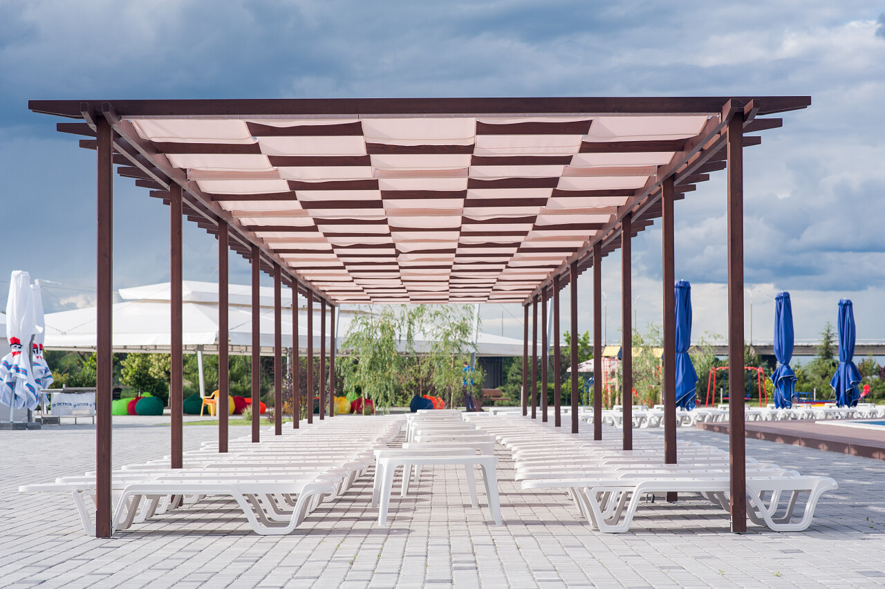 泳池遮阳篷下的太阳躺椅床